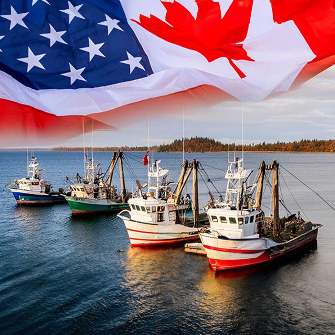 US and Canadian flags flutter above a small fleet of fishing vessels.